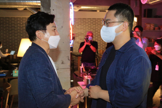 국민의힘 대선 예비후보인 원희룡(왼쪽) 전 제주지사가 16일 서울 노원구 한 식당을 운영하는 36세 청년 자영업자 이종민(오른쪽) 대표를 만나 악수를 나누고 있다.원희룡 캠프 제공 사진